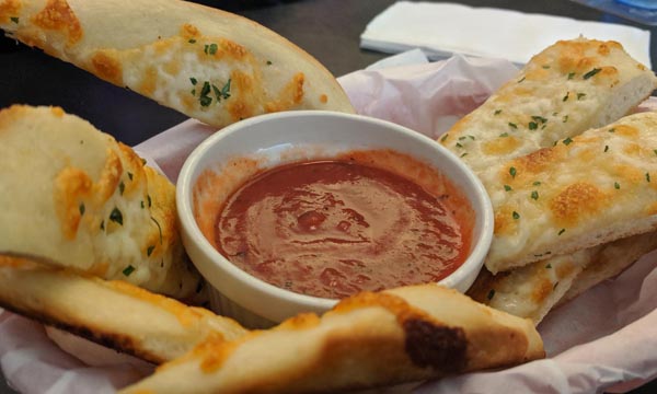 Jake's pizza sticks with a cup of their homemade pizza sauce